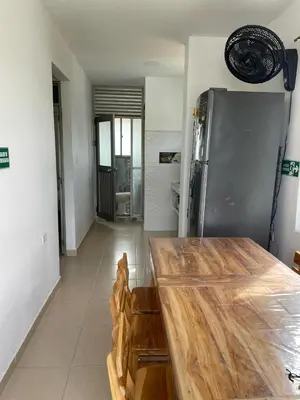 a kitchen with a wooden table and a refrigerator at Cabañas Melany in Coveñas