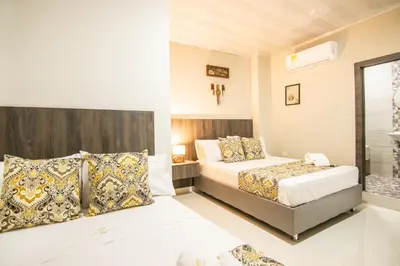 a hotel room with two beds and a window at Cienaguas Hotel in Ciénaga