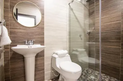 a bathroom with a toilet and a sink and a mirror at Cienaguas Hotel in Ciénaga
