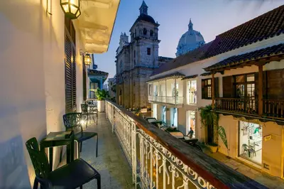 a balcony with tables and chairs on a city street at San Pedro Claver Luxury in the walled city in Cartagena de Indias
