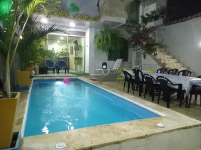 a pool in a room with chairs and a table at Casa Playa Arreboles in Cartagena de Indias