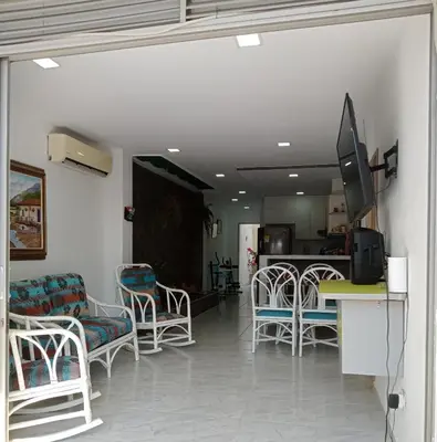 a living room with chairs and a table and a tv at Casa Playa Arreboles in Cartagena de Indias