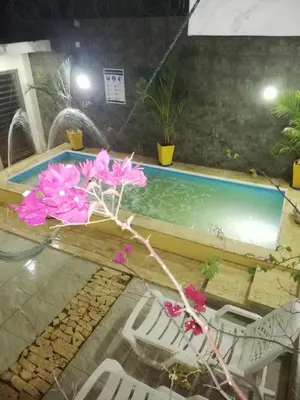 a pool with chairs and flowers on a glass table at Casa Playa Arreboles in Cartagena de Indias
