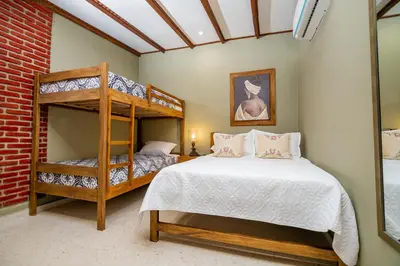 a bedroom with two bunk beds and a brick wall at Scalea Di Mare Hotel in Cartagena de Indias