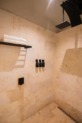 a bathroom with a shower with shoes on the wall at Scalea Di Mare Hotel in Cartagena de Indias