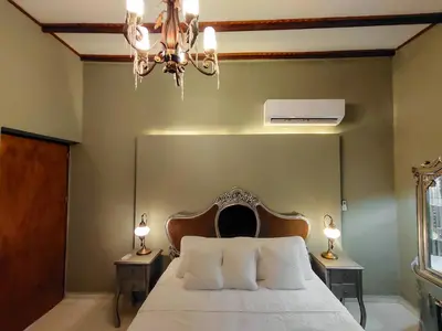 a bedroom with a bed with a chandelier and two lamps at Scalea Di Mare Hotel in Cartagena de Indias