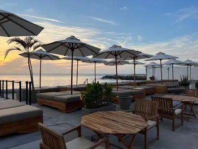 a patio with tables and umbrellas on the beach at Wala Hotel and Beach Club in Cartagena de Indias