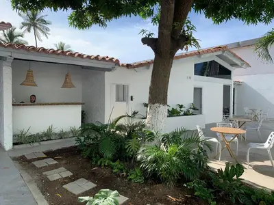 a white house with a table and a tree at Wala Hotel and Beach Club in Cartagena de Indias