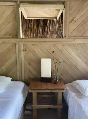 a room with two beds and a table with a laptop at Centro Ubuntu in Isla Grande