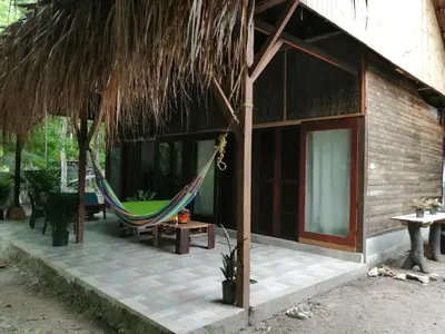 a hammock on the outside of a house at Centro Ubuntu in Isla Grande