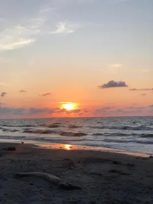 a sunset on the beach with the ocean at Cabaña frente al mar Encanto del Viento in San Bernardo del Viento