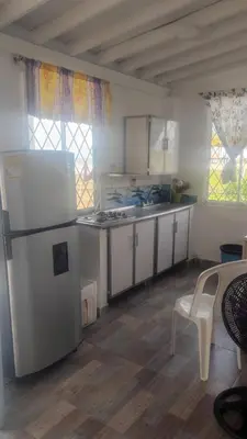 a kitchen with white cabinets and a white refrigerator at Cabaña frente al mar Encanto del Viento in San Bernardo del Viento