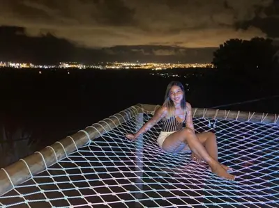 a woman is laying on a white net at ADA MARINA, hotel campestre con la mejor vista a Cartagena in Turbaco