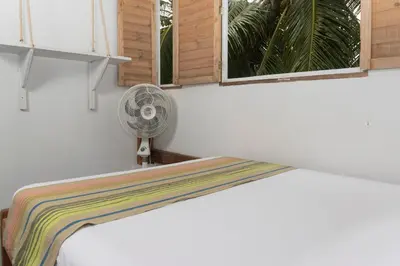 a white room with a fan and a window at Quatro palos in Rincón