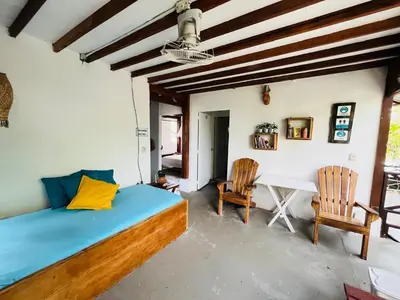 a bedroom with a bed and two chairs and a table at Quatro palos in Rincón