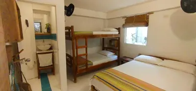 a small room with two bunk beds and a bathroom at Quatro palos in Rincón