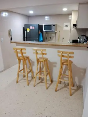 a kitchen with three wooden stools at a counter at Apartamento mar in Cartagena de Indias