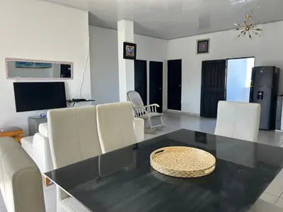 a dining room with a black table and white chairs at ARMANI in Puerto Colombia