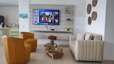 a living room with a couch and a tv on a wall at Cabaña Apartamento En Coveñas - Fontaine Bleu in Coveñas