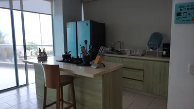 a kitchen with a counter with a chair in it at Cabaña Apartamento En Coveñas - Fontaine Bleu in Coveñas