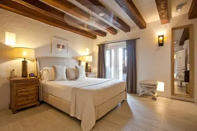 a bedroom with a large white bed and a mirror at Hotel Boutique Casa del Coliseo in Cartagena de Indias