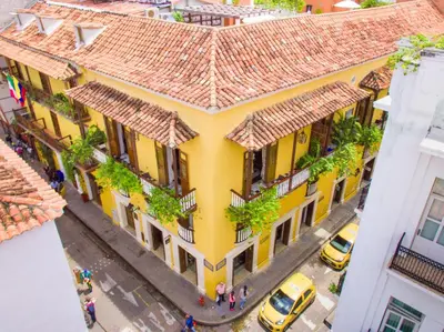 an overhead view of a yellow building with plants at Hotel Boutique Casa del Coliseo in Cartagena de Indias