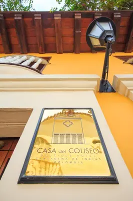 a sign on the side of a building with a street light at Hotel Boutique Casa del Coliseo in Cartagena de Indias
