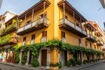 a yellow building with balconies on a street at Hotel Boutique Casa del Coliseo in Cartagena de Indias
