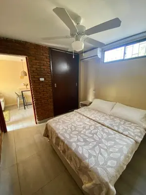 a bedroom with a bed and a ceiling fan at Apartaestudios - Casa Tamarindo in Aracataca