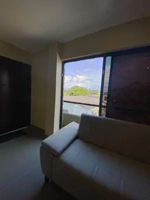 a living room with a couch and a large window at Apartaestudios - Casa Tamarindo in Aracataca