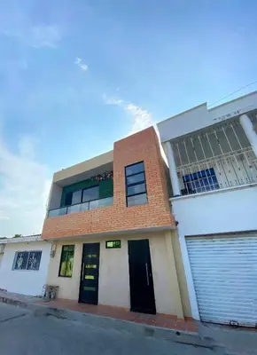 a building with doors and windows on a street at Apartaestudios - Casa Tamarindo in Aracataca