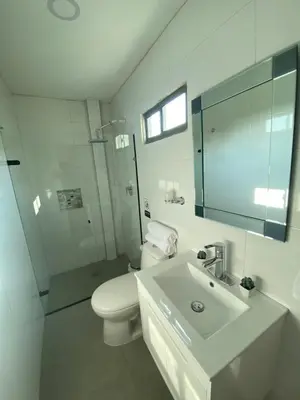 a white bathroom with a toilet and a sink at Apartaestudios - Casa Tamarindo in Aracataca
