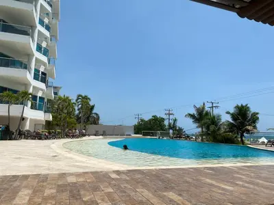a person swimming in a swimming pool next to a building at Playa -Boquilla -Apto en Condominio in Cartagena de Indias