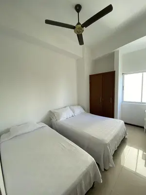 two beds in a bedroom with a ceiling fan at Hermoso y amplio apartamento en Cartagena de Indias in Cartagena de Indias