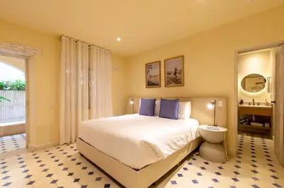 a bedroom with a large bed with blue pillows at B Haus Hotel Boutique in Cartagena de Indias