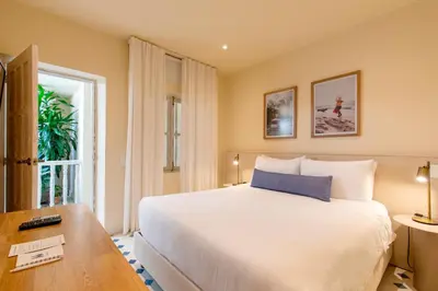 a bedroom with a large white bed and a table at B Haus Hotel Boutique in Cartagena de Indias