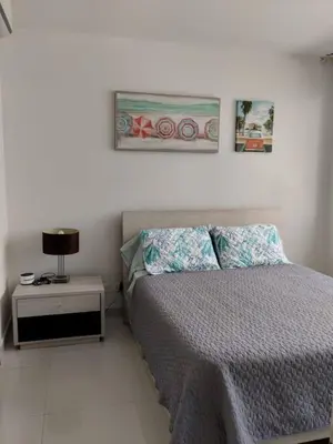 a bedroom with a bed and a table with a lamp at Cartagena Genius Morros frente al mar in Cartagena de Indias