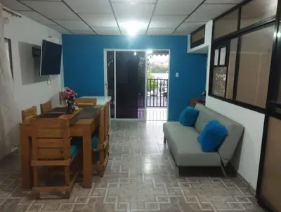 a living room with blue walls and a table and a couch at Apartamentos San Felipe in Cartagena de Indias