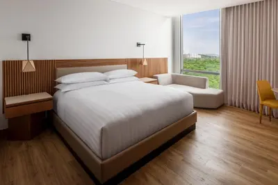 a bedroom with a large white bed and a chair at Barranquilla Marriott Hotel in Barranquilla