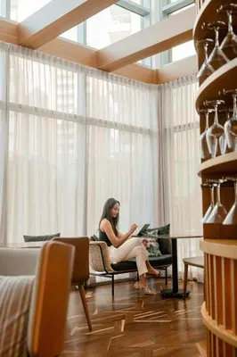 a woman sitting on a chair in a room with a laptop at Barranquilla Marriott Hotel in Barranquilla