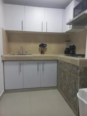a kitchen with white cabinets and a sink at La casita de max y tim apartaestudio 4to piso in Cartagena de Indias