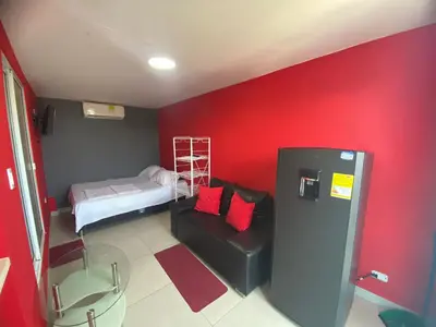 a room with a red wall with a bunk bed at La casita de max y tim apartaestudio 4to piso in Cartagena de Indias
