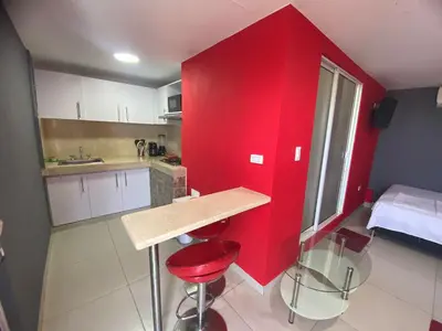 a small kitchen with red walls and a red wall at La casita de max y tim apartaestudio 4to piso in Cartagena de Indias