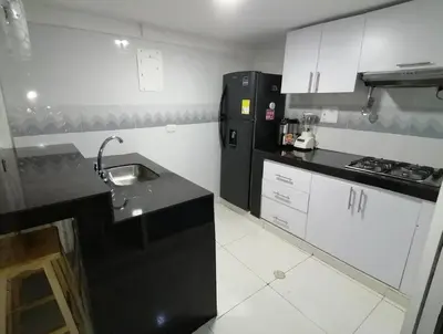 a kitchen with a sink and a black refrigerator at Casa La Fe in Cartagena de Indias