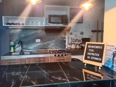 a kitchen with a counter with a sink and a microwave at Apartamento Exclusivo - Caribe Campestre Coveñas in Coveñas
