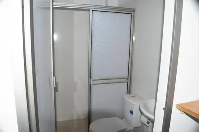 a bathroom with a toilet and a glass shower door at ZABDI COVEÑAS in Coveñas