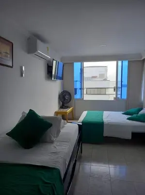 a hotel room with two beds and a window at Apartamento con VISTA AL MAR, A una cuadra de la PLAYA. Piso 16 in Cartagena de Indias