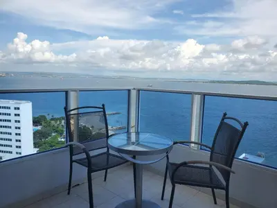 a balcony with a table and two chairs and the ocean at Apartamento con VISTA AL MAR, A una cuadra de la PLAYA. Piso 16 in Cartagena de Indias