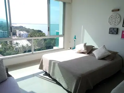 a bedroom with a bed and a large window at Costa Azul Suite 804 in Santa Marta
