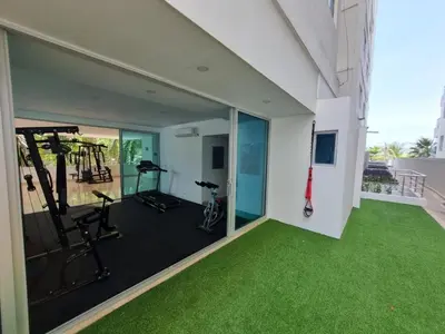 an indoor gym with green carpeted flooring and glass windows at 1 Bedroom Apartment Morros. Beach access in Cartagena de Indias